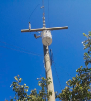 Miniatura de la vista frontal inferior de un poste para cableado eléctrico con un transformador 50Kva fijado en la parte superior.