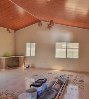 Miniatura de vista interior de la casa con un lavabo, dos candelabros pequeños, una ventana doble y una ventana pequeña, encielado PVC con diseño de madera, piso de cerámica y materiales usados en la construcción.